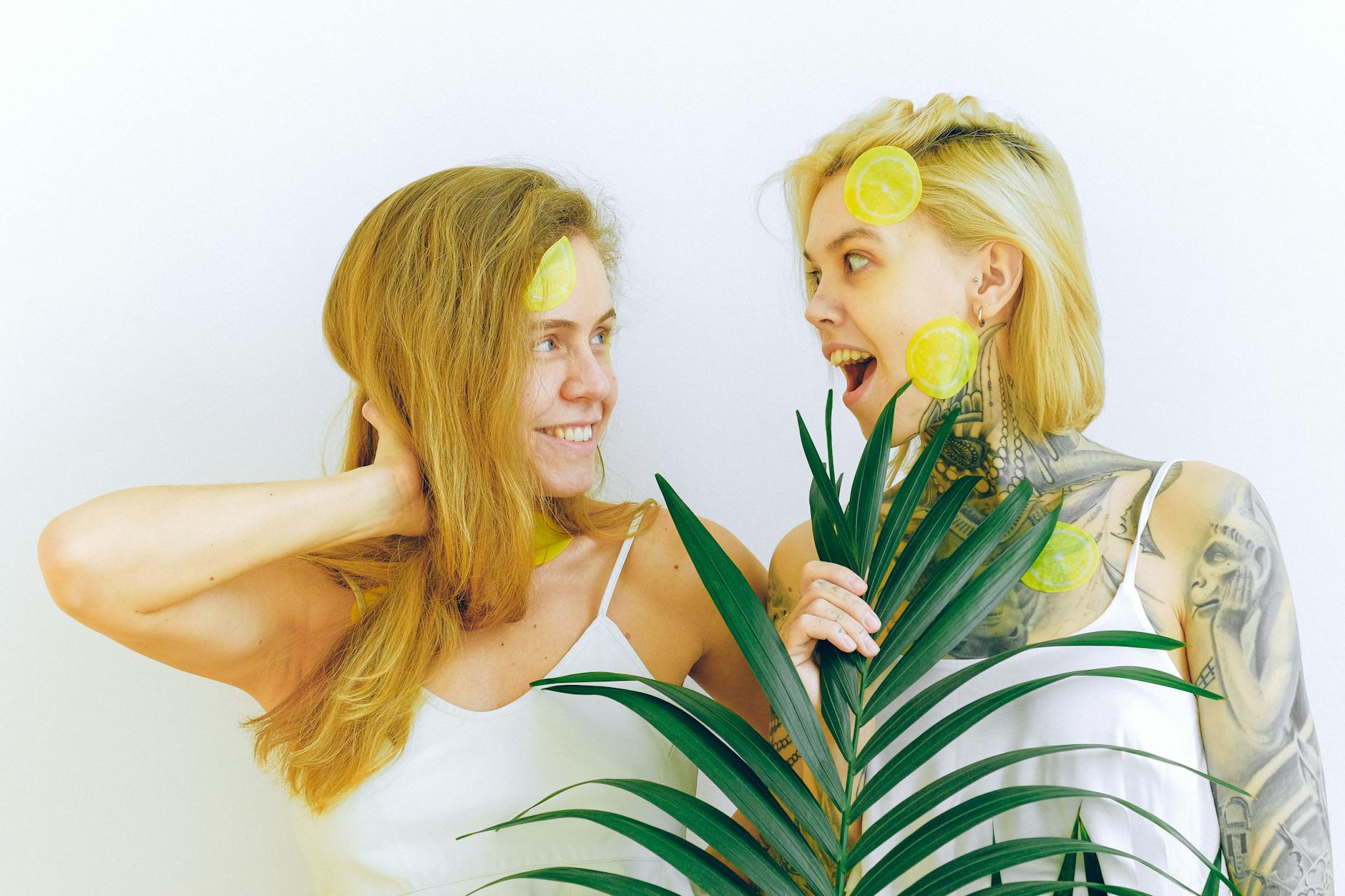 Two women smiling together with lemon slices, expressing genuine connection and joy.