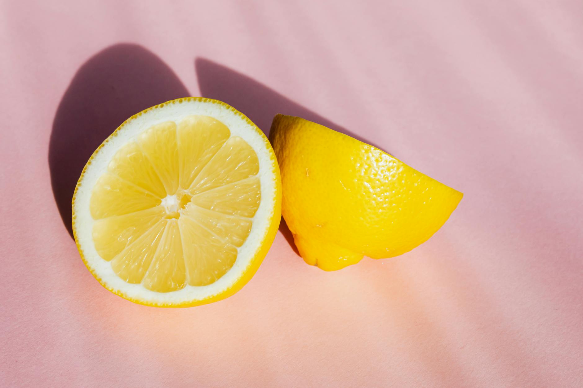 Close-up of a hand holding an orange vibrator against a minimalistic purple backdrop, showcasing modern sensuality and gentle touch