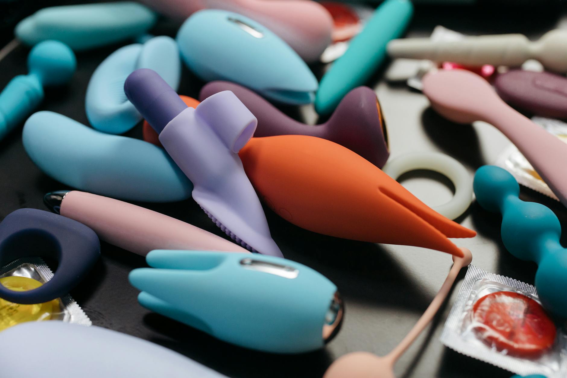 An array of vibrant clitoral vibrators and adult toys in a close-up view.