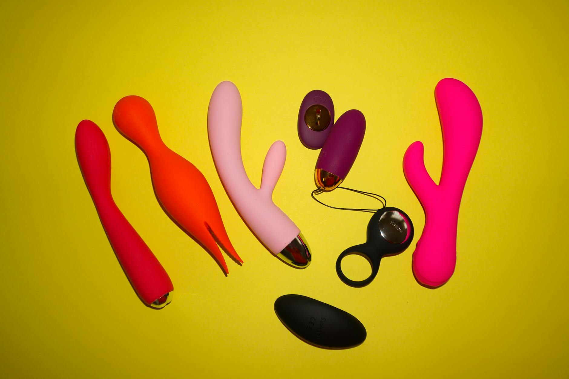 A hand holding a vibrator against a purple backdrop, symbolizing modern sensuality and self-exploration.